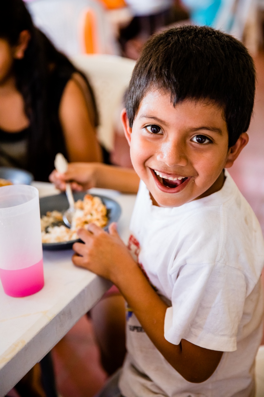 little boy happy to have a meal from ORPHANetwork on nonprofit photography trip
