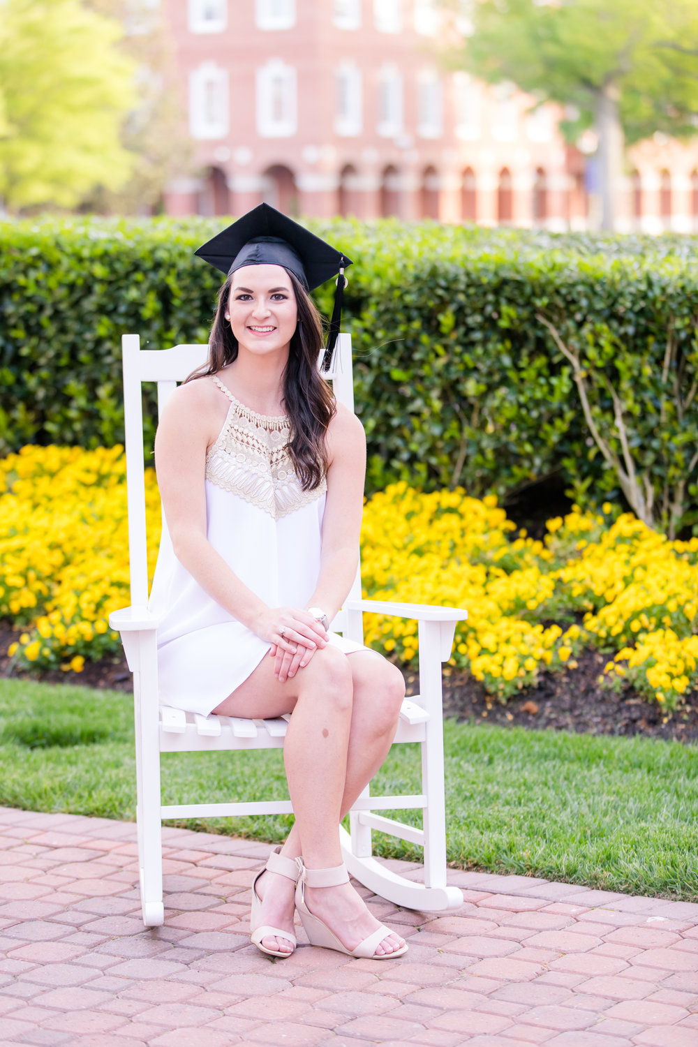 Senior girl in white dress on chair at CNU campus