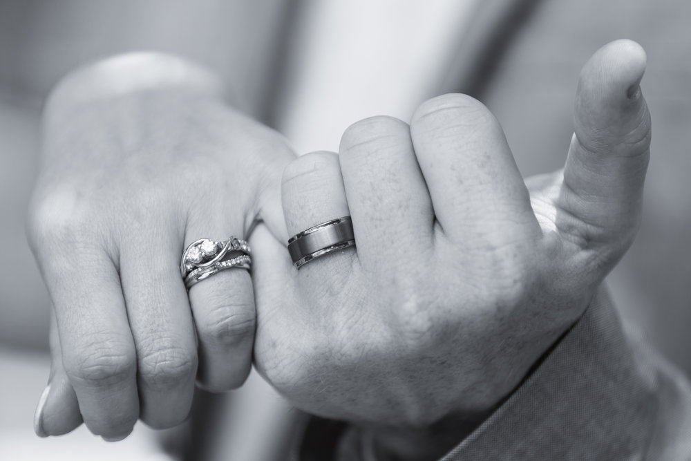 hands of bride and groom with rings - twisting pinkies 