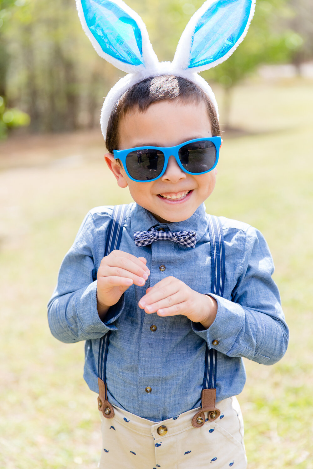 cute boy with blue sunglasses and bunny ears smiling for Williamsburg family photographer