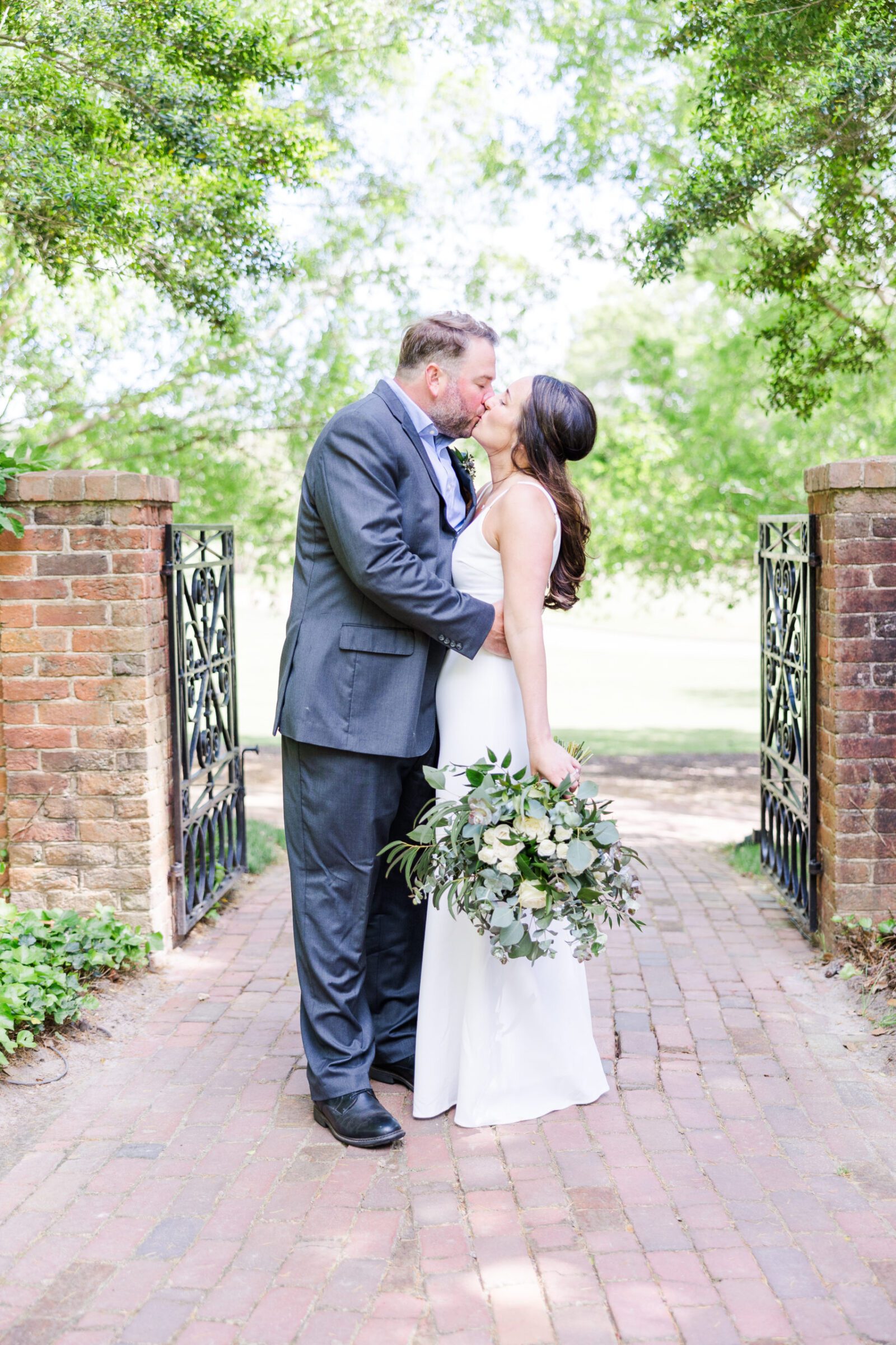 Bride and groom embrace in a hidden spot, the Oval Garden, for their Williamsburg Inn elopement