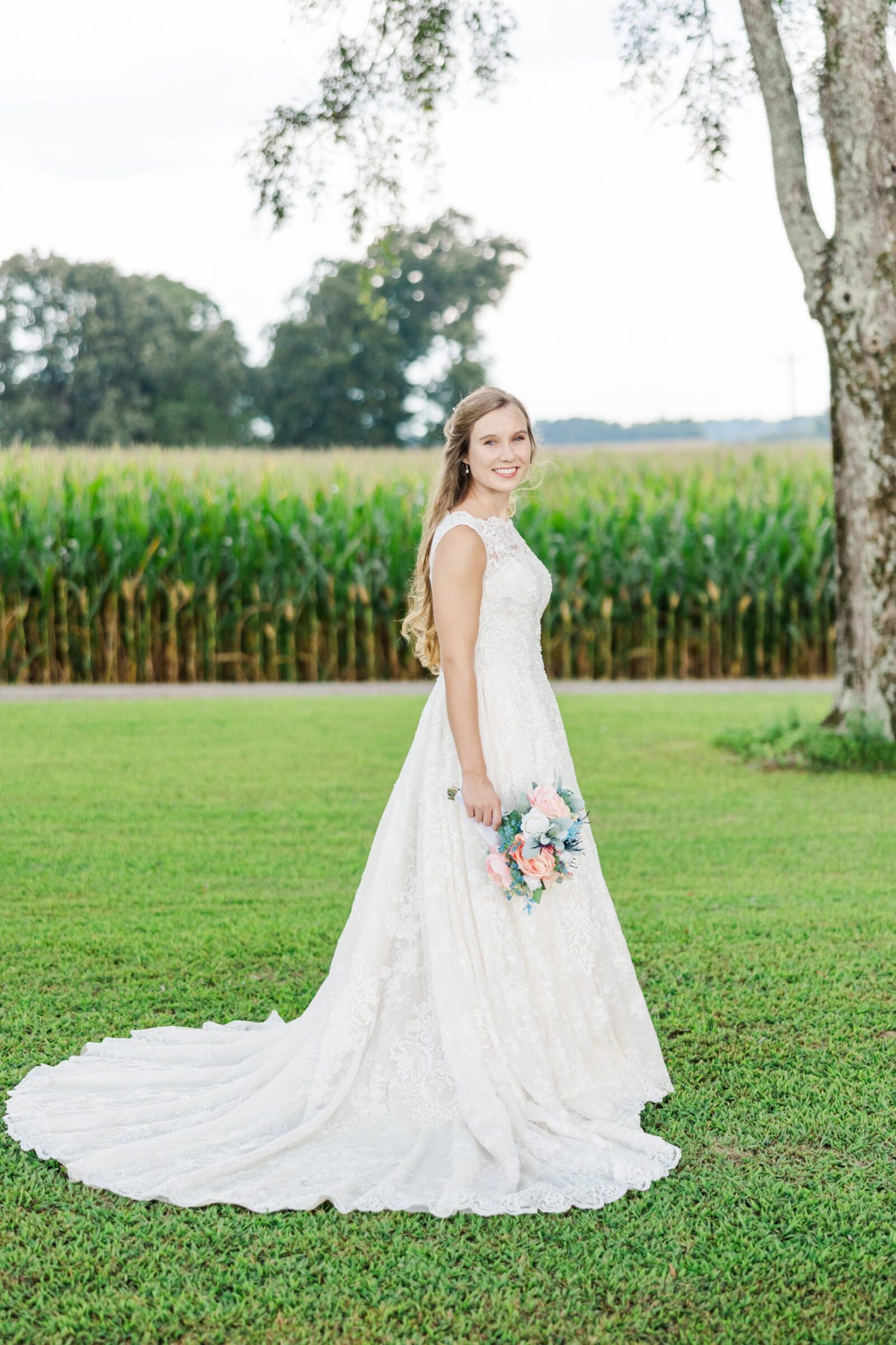 Dana holding her bouquet in front of a cornfield for her outdoor Virginia bridal portait