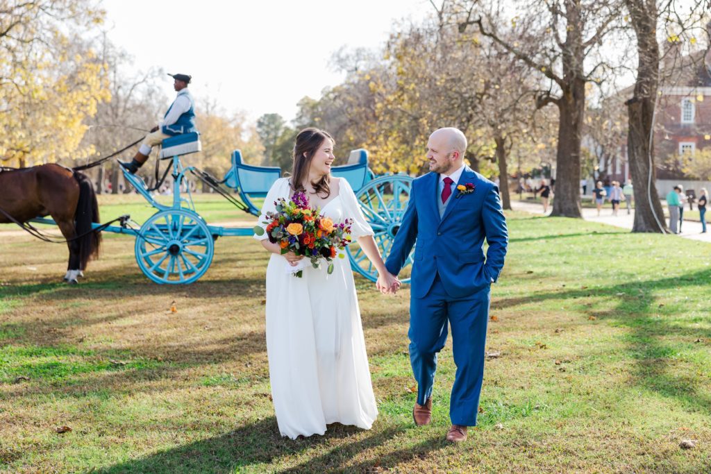 Bride and groom on the Governor's Palace lawn with horse and carriage in the background 