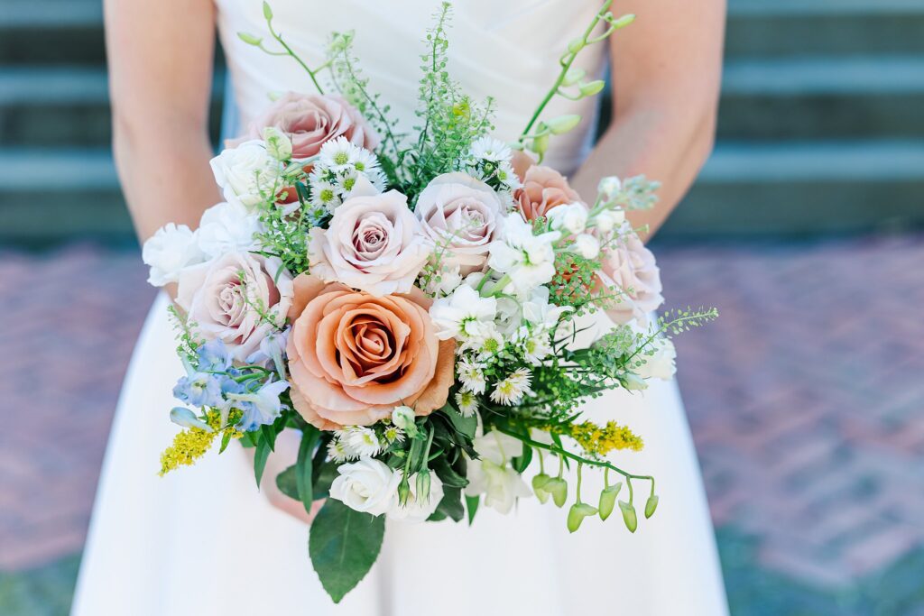 stunning pink, blue and white bouquet with bride holding it 