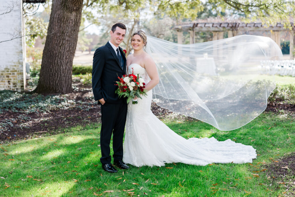 bride's veil flows in wind with sun gleaming for couple's portrait at Williamsburg Inn
