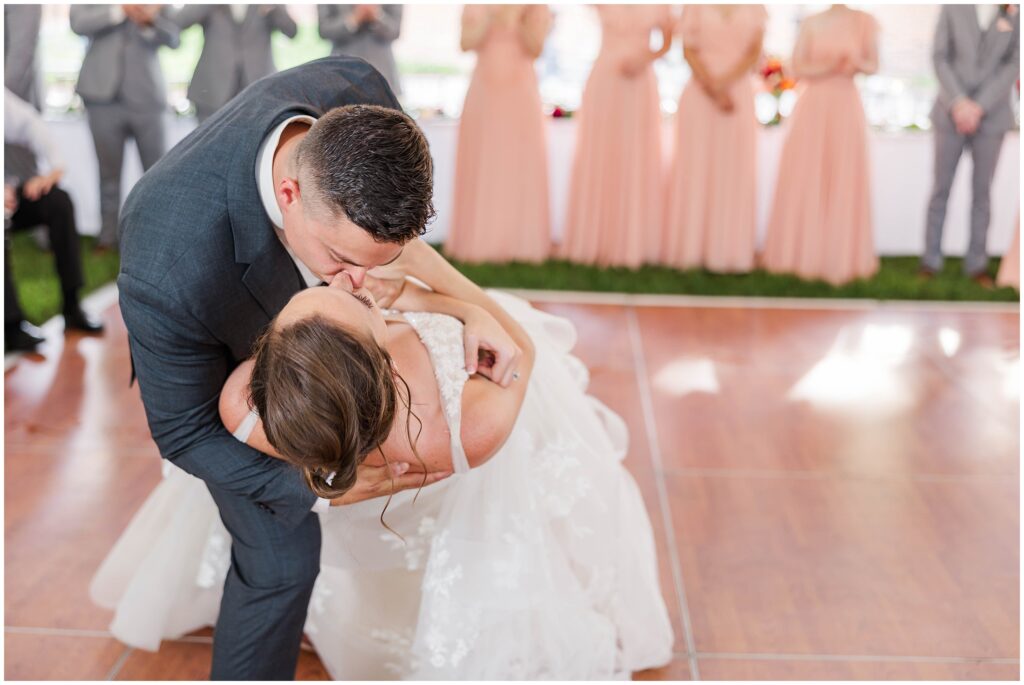 groom dips bride during first dance for kiss at Colonial Williamsburg wedding
