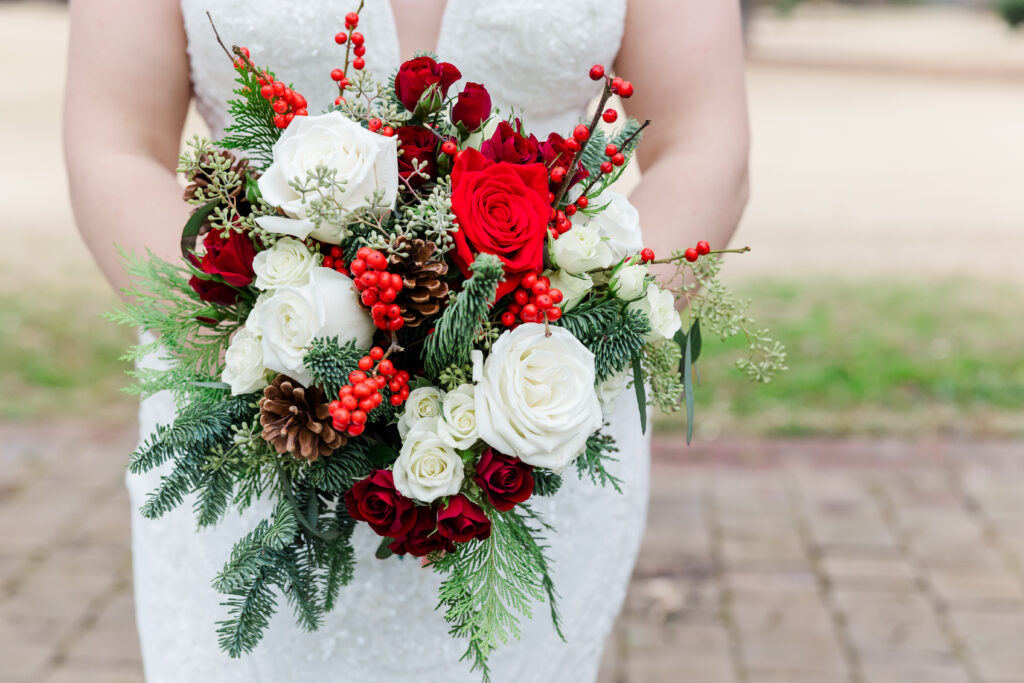 Red and white rose bouquet with pine cone accents for winter Williamsburg Inn wedding