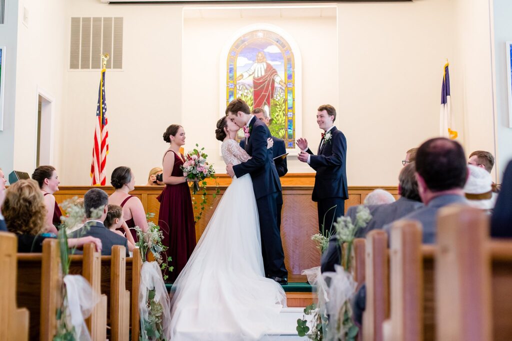 first kiss in sanctuary at traditional church wedding in virginia