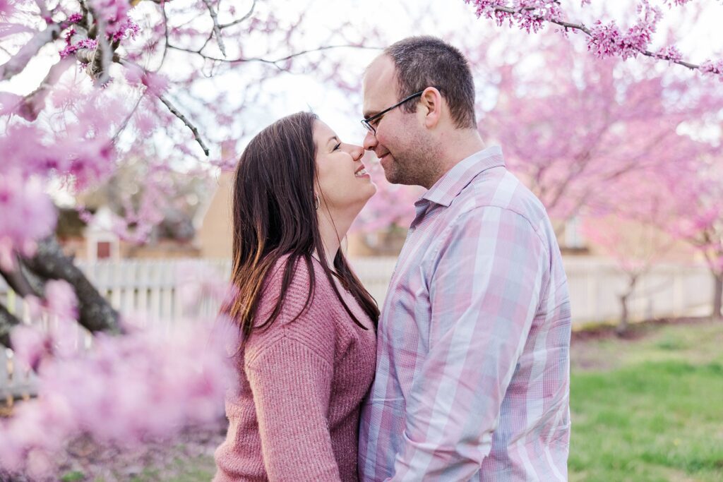 pink blossoms frame couple at spring engagement photos