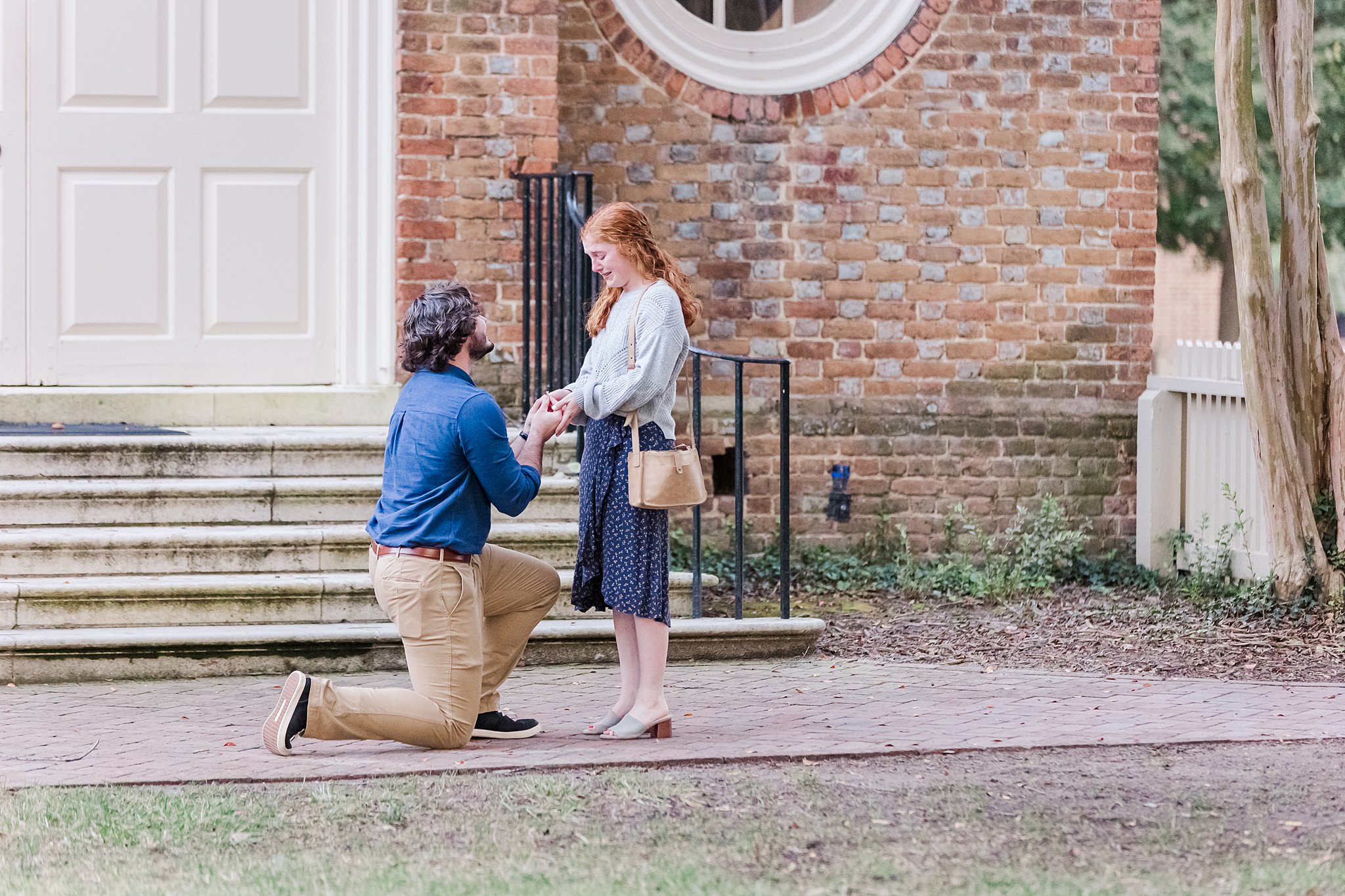 William & Mary alum on one knee proposing in front of Wren Chapel