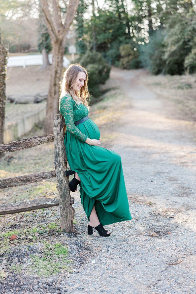 woman gazes down at pregnant belly during maternity session