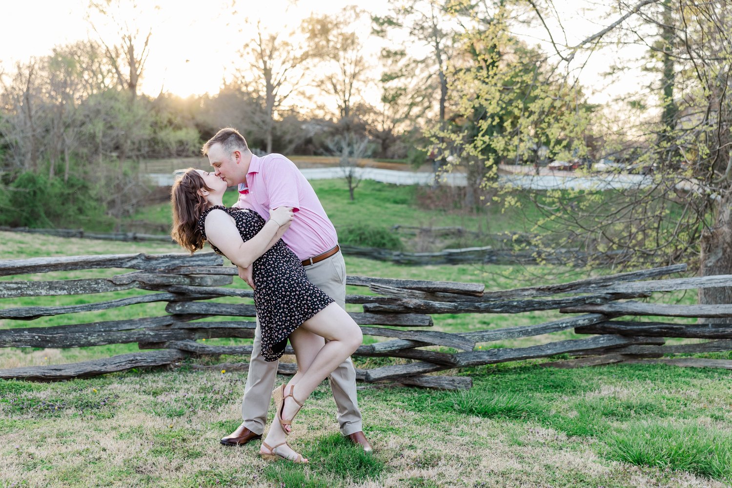 man dips fiance for a kiss during spring engagement in Colonial Williamsburg