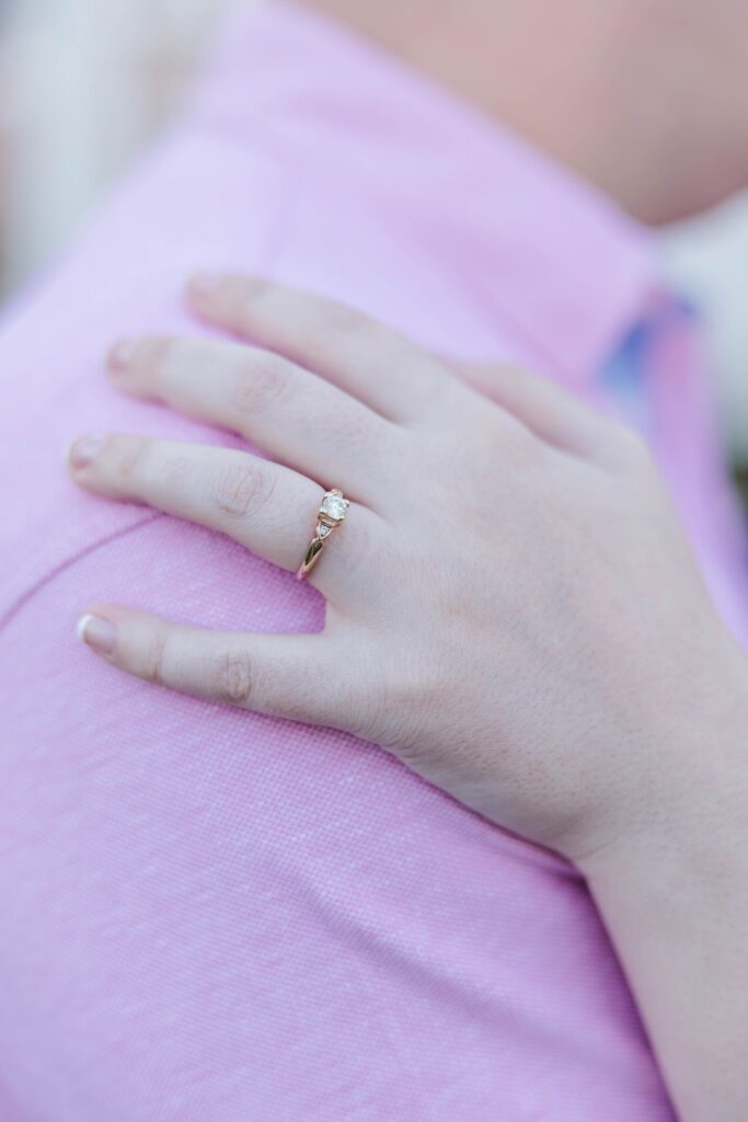 girl's hand on fiance's shoulder showing off engagement ring
