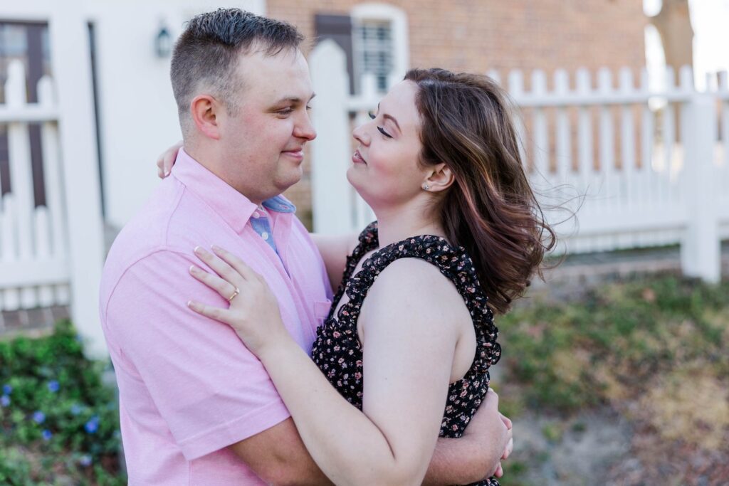 couple gazes into each other's eyes during spring engagement session in Colonial Williamsburg garden