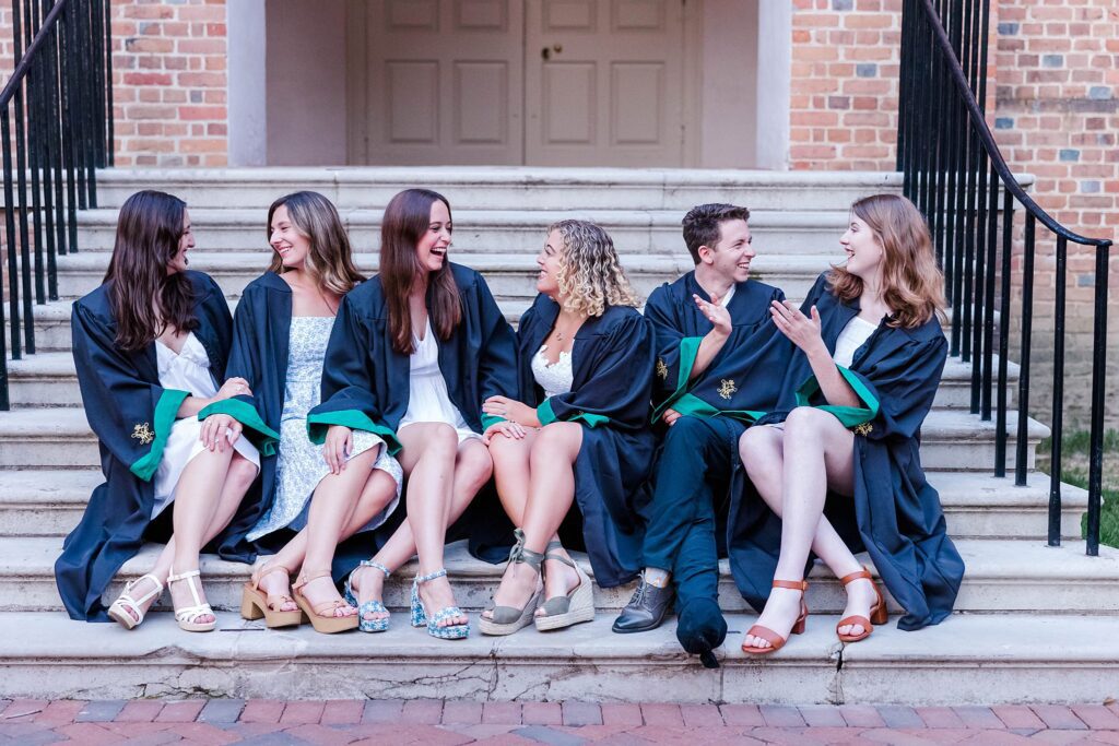 Seniors laugh sitting on the Wren Building steps from the W&M Class of 2023
