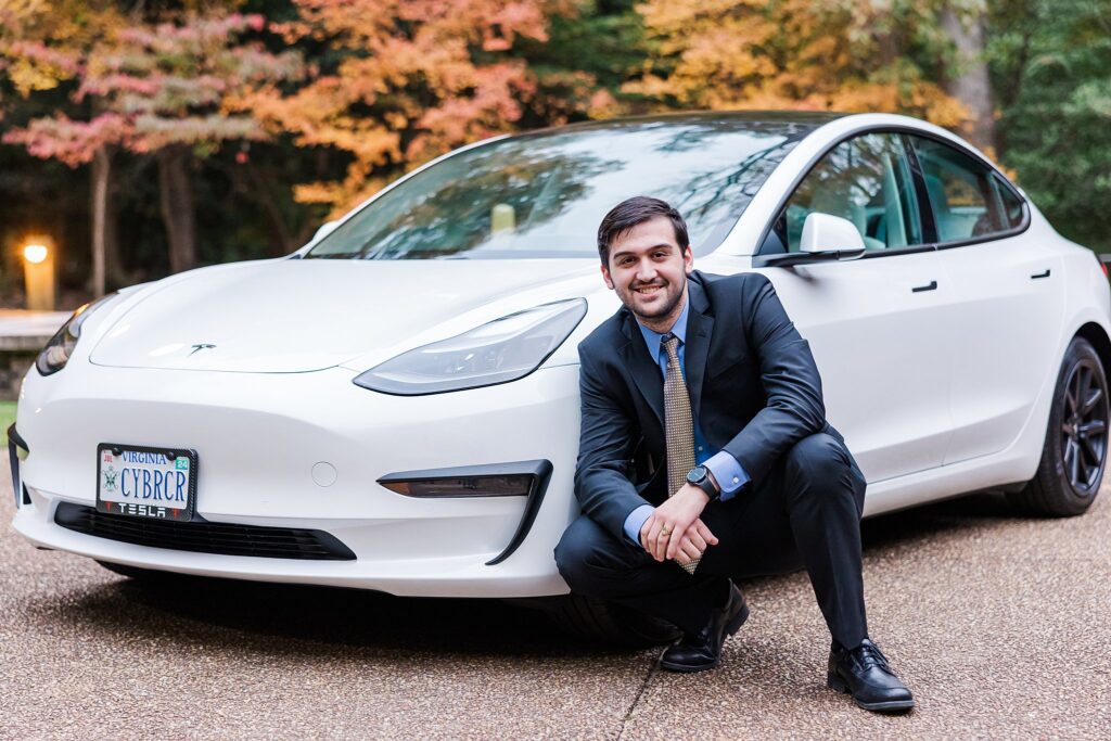 senior from W&M Class of 2023 posing with his Tesla