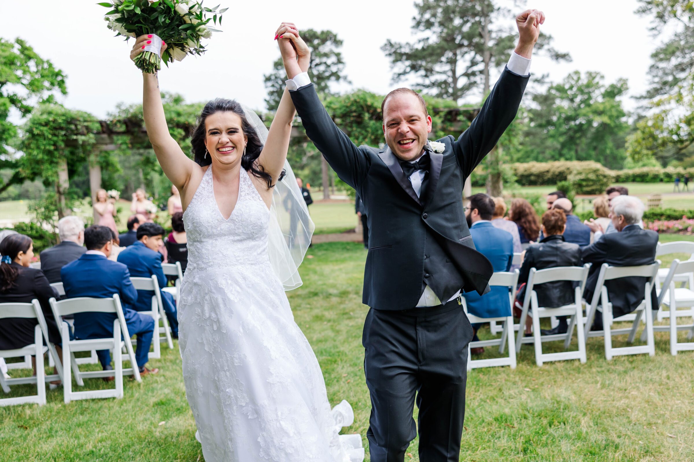 couple raises hands in celebration after their destination wedding at the Williamsburg Inn