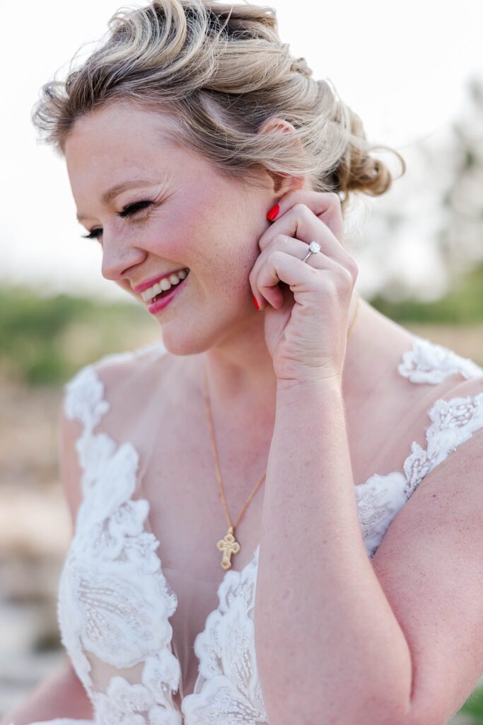 bride holds earring at bridal portrait session