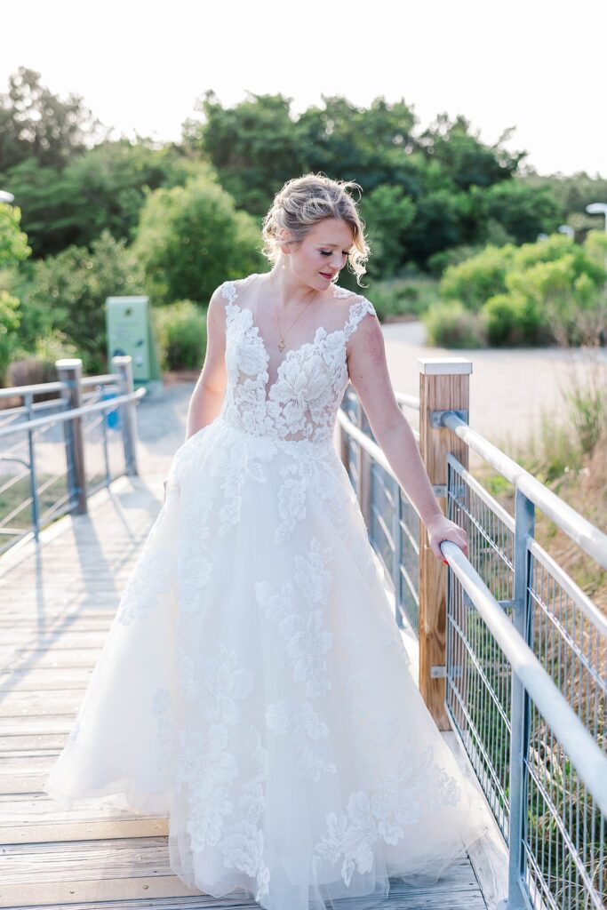 bride stands on bridge and looks down at arm