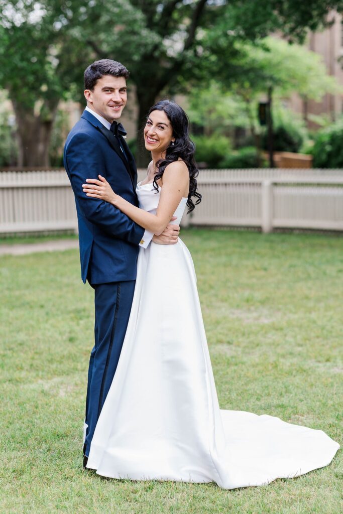 bride and groom smile for photo in Wren courtyard at William and Mary wedding