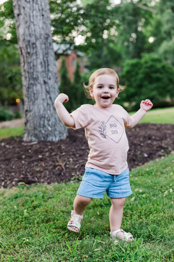 toddler wearing big sis shirt to announce new baby at family mini session