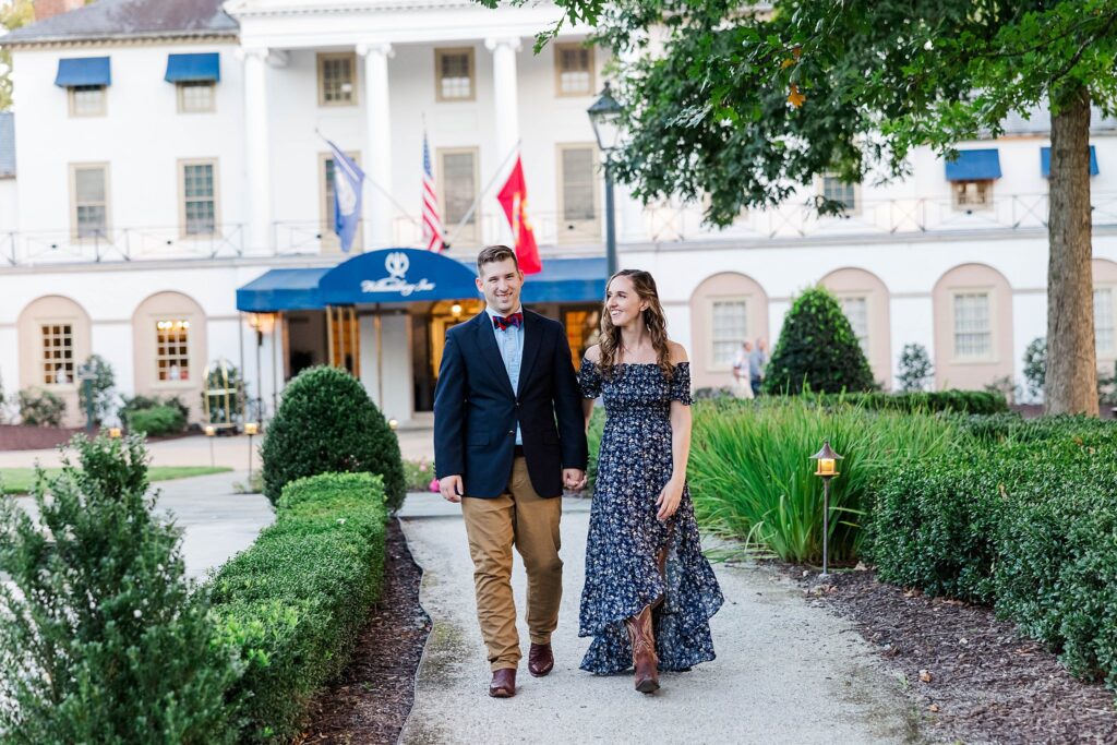 couple walks away from Williamsburg Inn at fall engagement session
