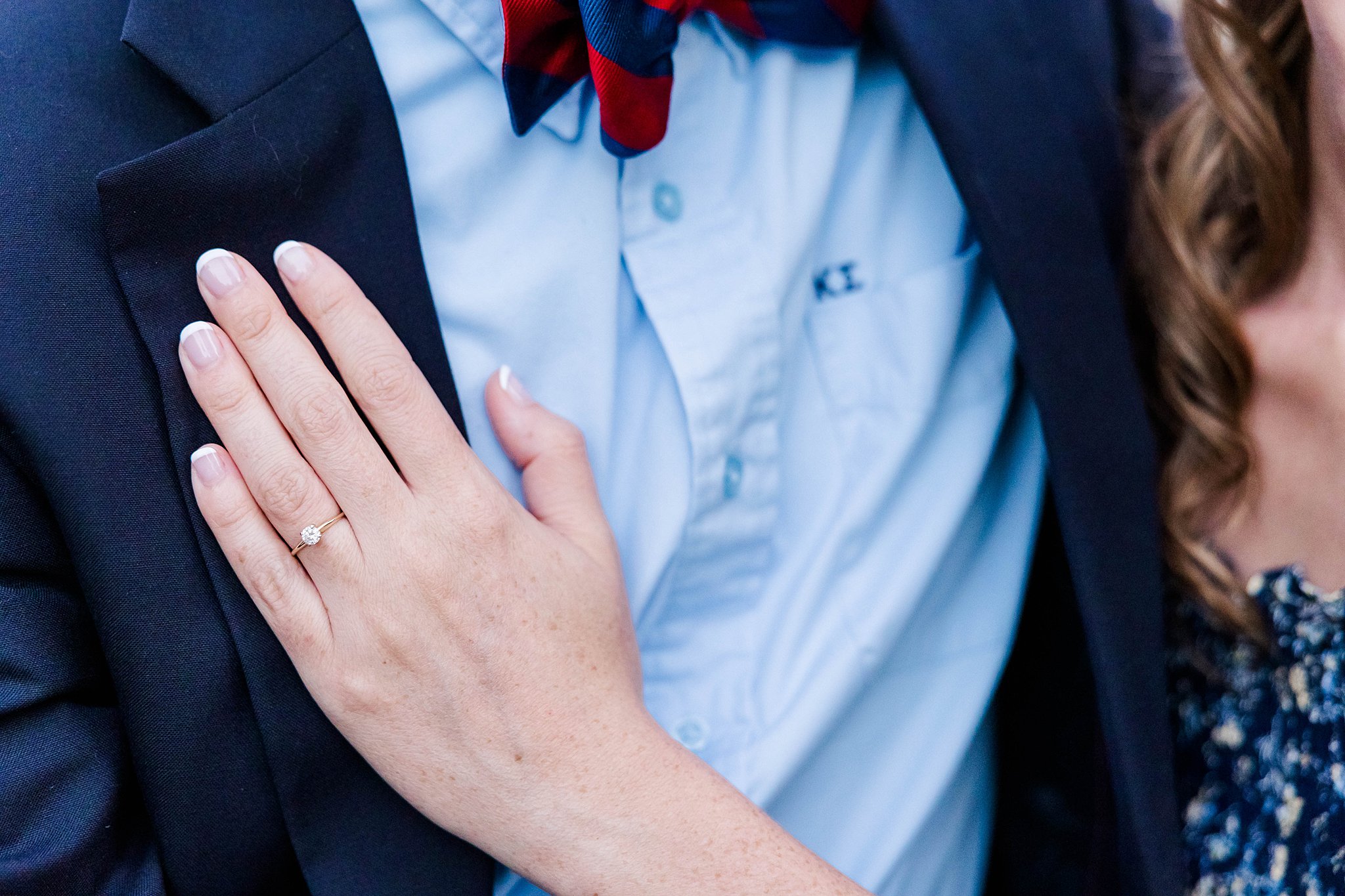 Hand on chest to show off engagement ring 