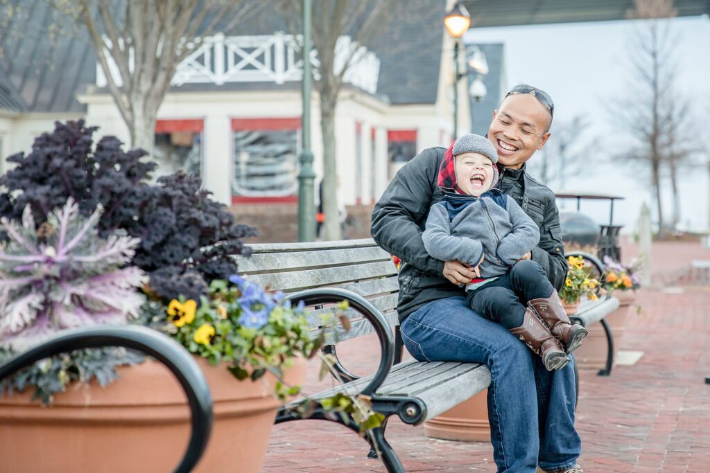 father and son laughing on a bench at Yorktown Beach boardwalk during my early photography story