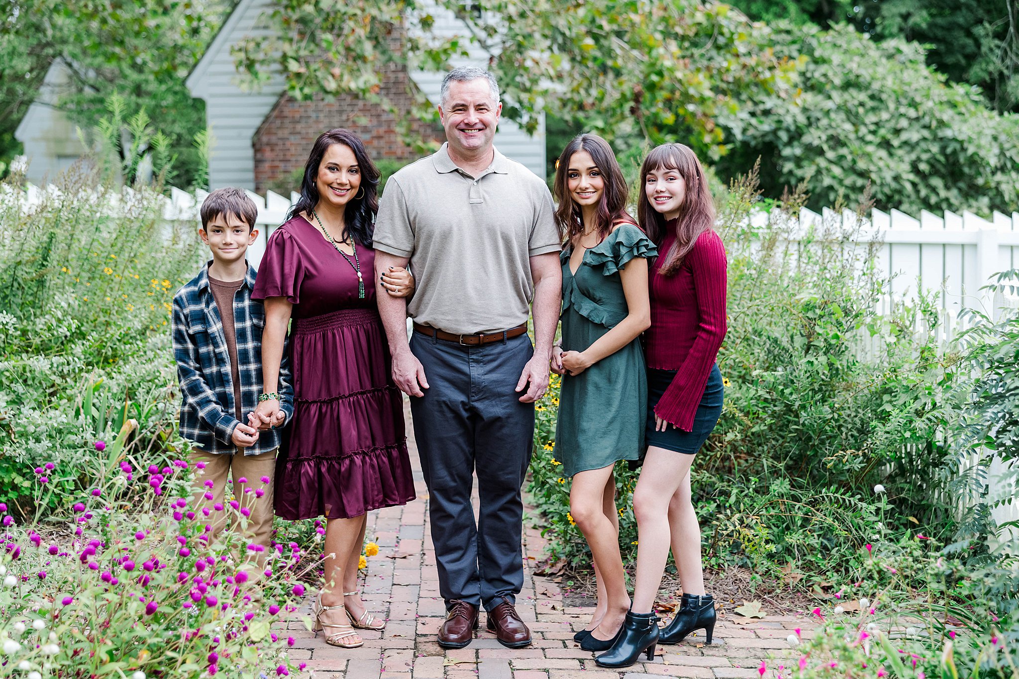 family poses in burgundy and green color scheme in garden in Colonial Williamsburg 