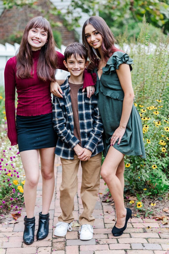 three siblings pose for portrait at fall family photos in Williamsburg