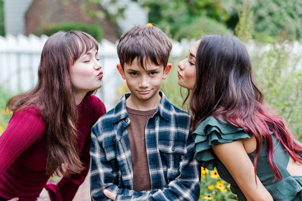cute image of brother with two sisters kissing