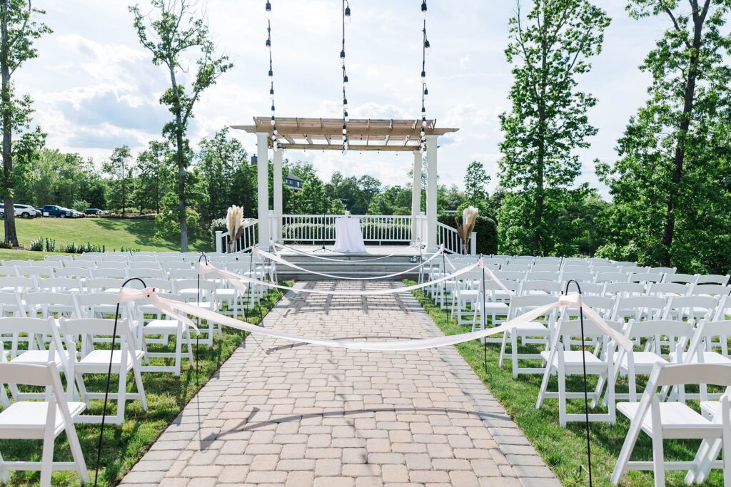 outdoor ceremony space with white chairs and gazebo at Saudi Creek Vineyards in Lanexa