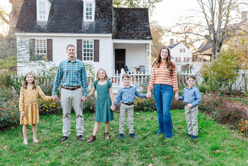 family holds hands in Colonial Williamsburg garden at family mini sessions