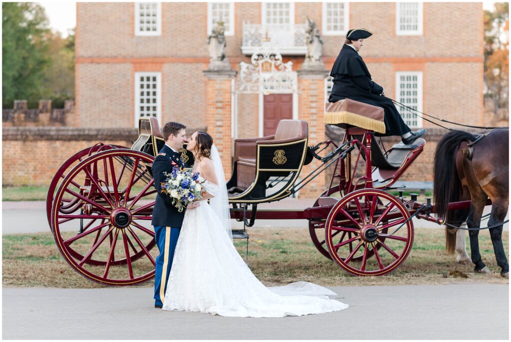 couple touches noses in front of horse and carriage in romantic Colonial Williamsburg Governor's Palace