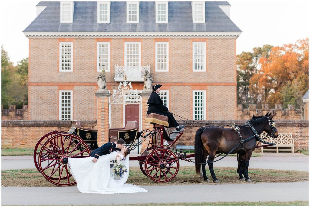Bride and groom dip and kiss in front of governor's place in Colonial Williamsburg 