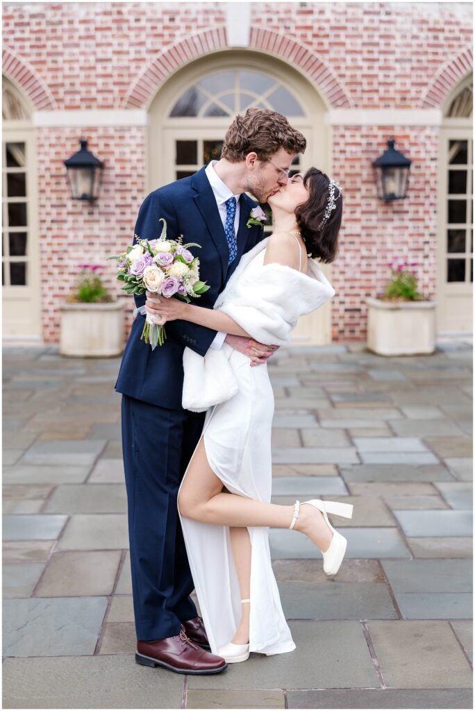 couple kisses with bride's foot popped for Christmas elopement in Williamsburg, VA