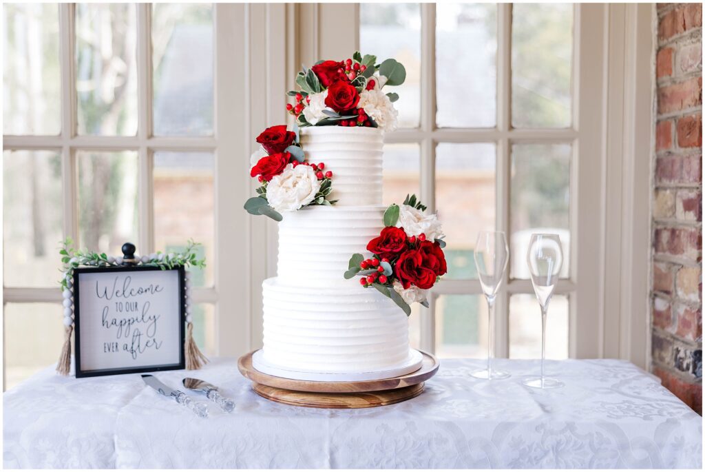beautiful cake with red flowers on patio at Cedars of Williamsburg Bed and Breakfast Wedding
