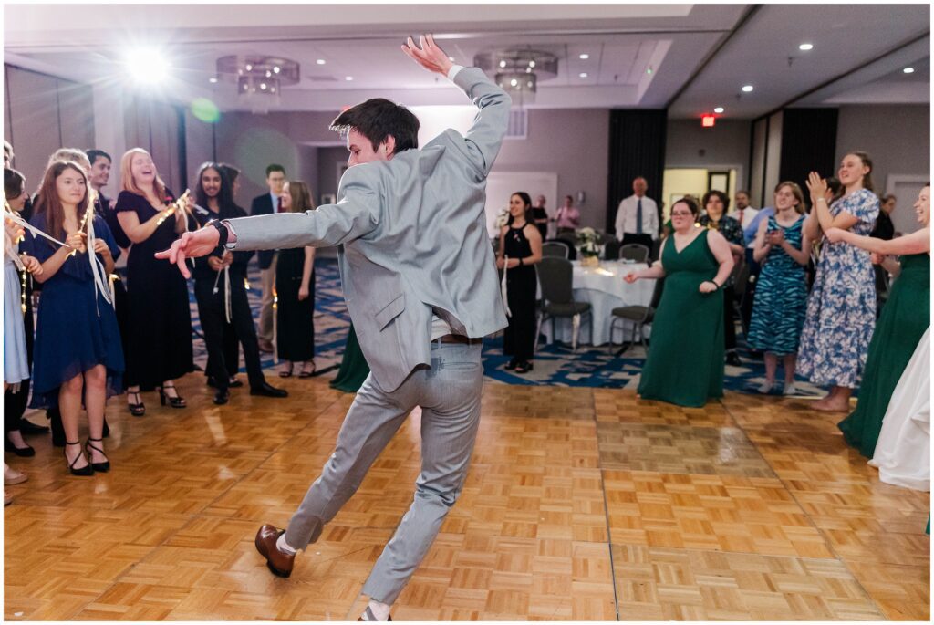 frozen shot of guy tearing up the dance floor at a wedding reception