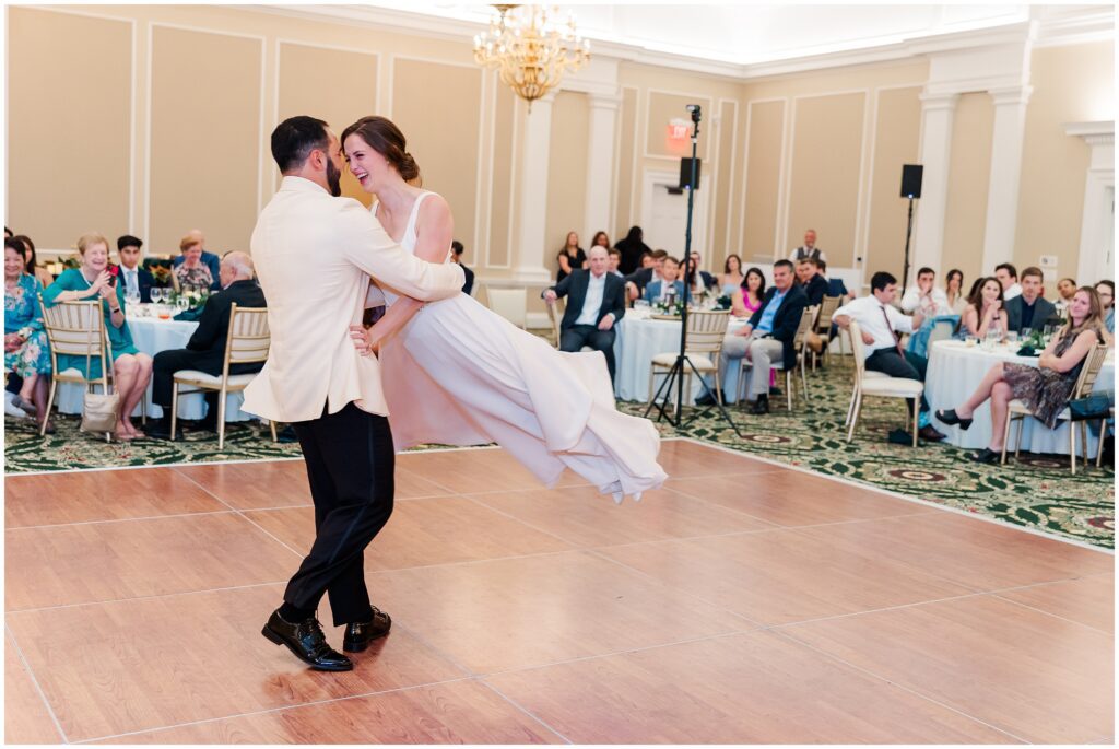 groom lifts bride for fun dance floor image