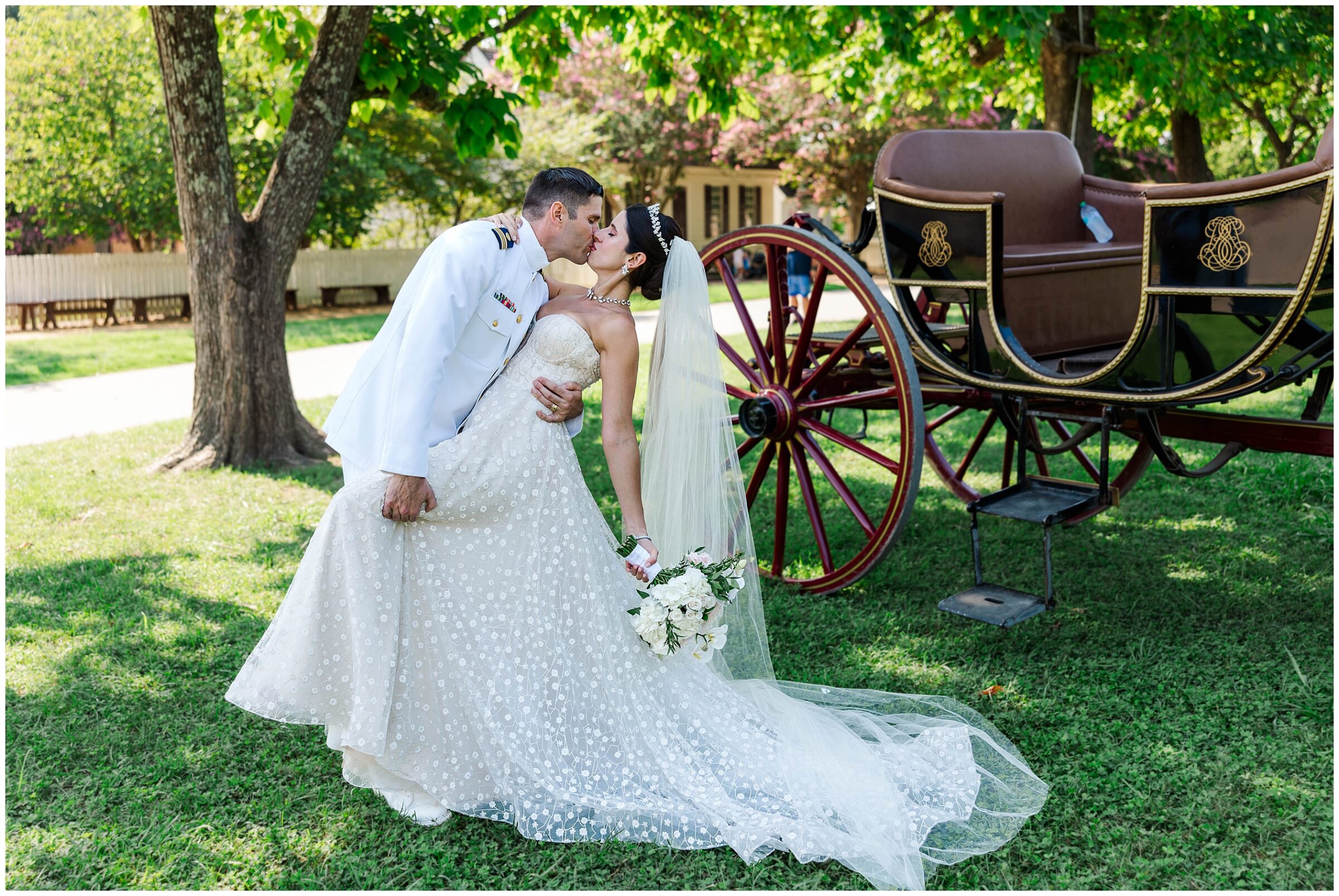 groom dips bride for kiss with horse and carriage behind