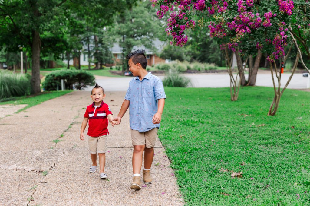 brothers walk down driveway smiling