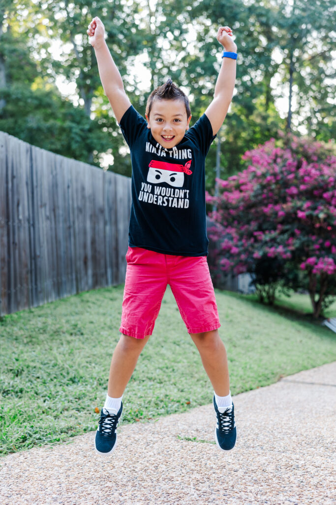 boy jumps in air for first day of school photo