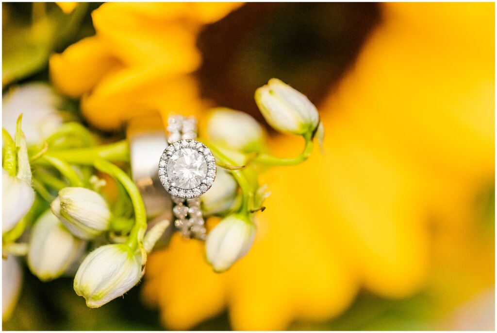 wedding rings hanging inside sunflower bouquet