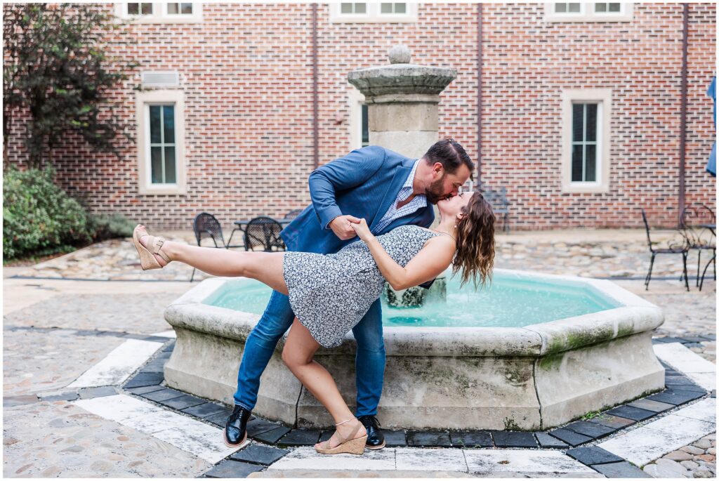 Couple dips in front of fountain at engagement at the Williamsburg Winery