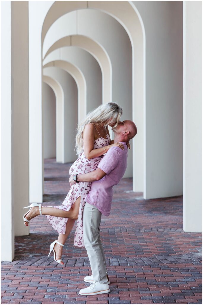 Groom lifting bride-to-be during engagement photos at Christopher Newport University.
